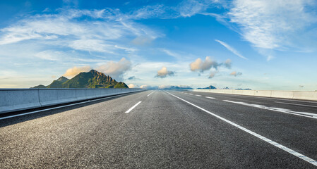 Asphalt highway road and mountain with beautiful sky clouds background