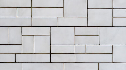 A modern wall design features a pattern of varying rectangular tiles in a light, neutral hue. The arrangement creates a geometric and textured appearance. #tilepattern #moderndesign