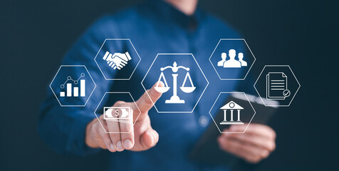 Businessman ensures legal compliance and corporate governance by interacting with the digital justice scale icon, symbolizing law, regulation, and ethical business standards.