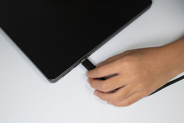 Hand connecting USB cable to laptop computer