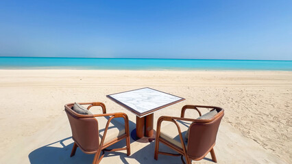 Elegant outdoor dining set with a marble table and rattan chairs directly on the white sand beach overlooking the turquoise ocean
