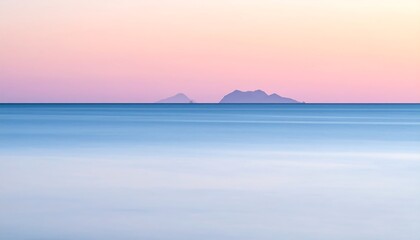 Serene ocean view at dawn or dusk, with islands in the distant background