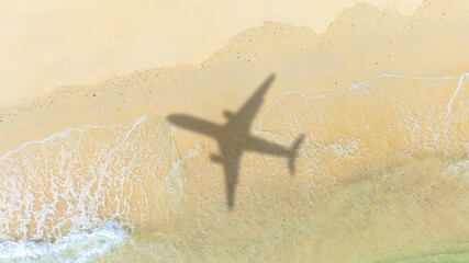 Aerial view of shadow passenger plane silhouette and sandy beach blue sea with waves at sea beach summer vacation sea travel concept	