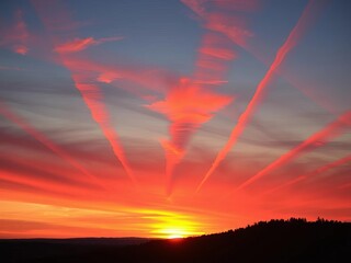 Crimson and orange streaks streak across the twilight sky as the sun dips below the horizon, a breathtaking view,  glow,  outdoor
