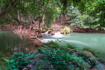  Tranquil Waterscape: A serene oasis of natural beauty, featuring a flowing river meandering through a lush forest, with hints of a cascading waterfall and reflecting the verdant foliage.