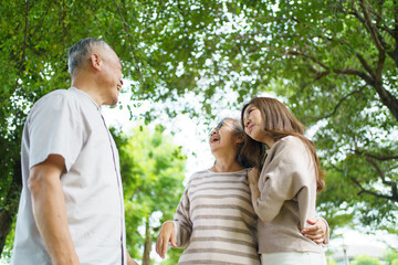 Fototapeta premium Asian family living together in park showing love, relationship and bonding.