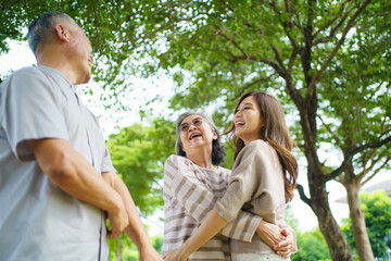 Asian family living together in park showing love, relationship and bonding.