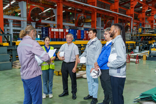 Diverse group of engineers and factory workers attending a morning briefing