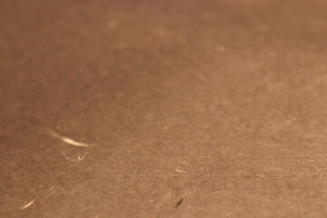 Close-up of a textured brown paper texture surface with subtle fibers.