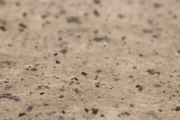 Close-up of textured beige paper texture surface with scattered dark specks.