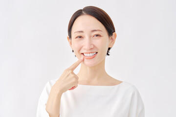 口を指差す女性　オーラルケアイメージ　白背景