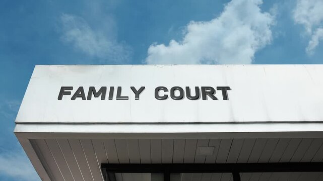 Family Court word sign prominently displayed on the official government building facade beneath a clear blue sky, signifying a courthouse handling domestic relations and juvenile matters.