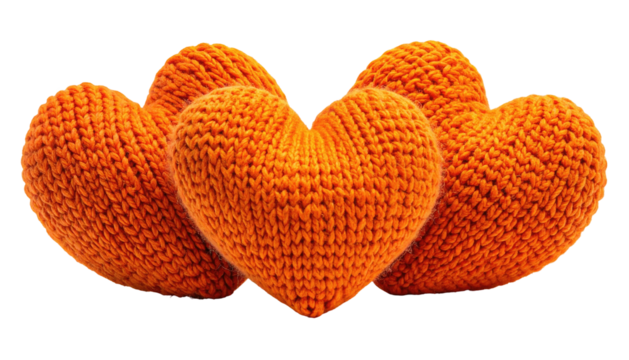 Four textured, knitted, vibrant orange hearts on a black background