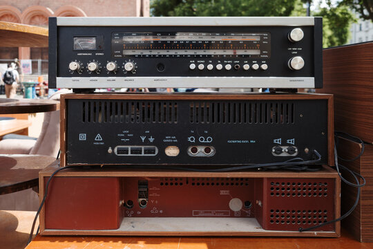 Close-up of three stacked vintage German audio receiver components at an outdoor flea market.
