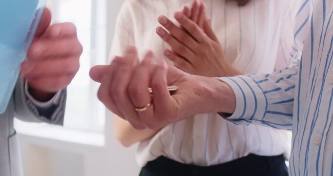 Agent hand giving house keys to couple homeowners. During contract signing, realtor guides buyers to finalize sale agreement. Meeting conveys trust and ownership transfer. Real estate purchase. - Powered by Adobe