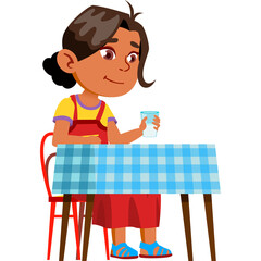 Young girl in red dress and yellow shirt sits at a blue checkered table holding a glass of water indoors
