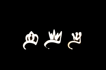 Fototapeta premium Light painting for 2026 Epiphany Day or Dia de Reyes Magos concept. Gold crowns, Star on black background