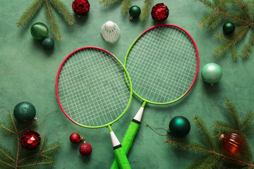 Composition with badminton rackets, Christmas balls and fir branches on color background