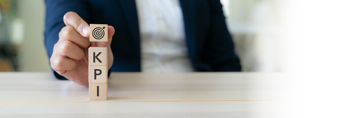 KPI target and business performance.  Measuring achievement effectively. Wooden blocks showing KPI letters and  target icon. Goal setting, performance evaluation and strategic business success.