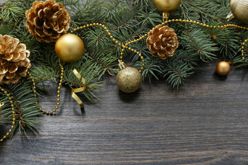 Christmas balls with beads and fir tree branches on wooden background
