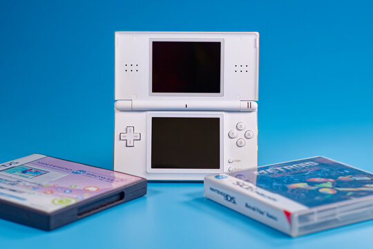 Fukuoka, Japan - november 4, 2025 : nintendo DS with two game cartridges isolated on blue background