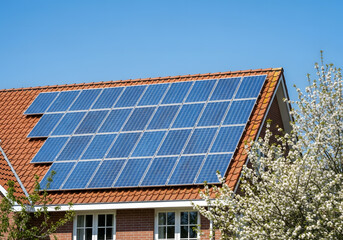 Fototapeta premium Residential solar thermal collectors on red tile roof | Eco-friendly home heating system installation on house | Renewable energy solution for sustainable living