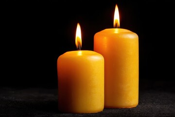 Warm Glow of Two Melting Candles on Black Background for In Memoriam Tribute