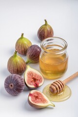 Juicy ripe figs on a white background, next to a jar of honey, stock photo isolate