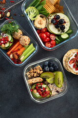 Bbox containing fresh fruits, vegetables, sandwiches, and nuts.