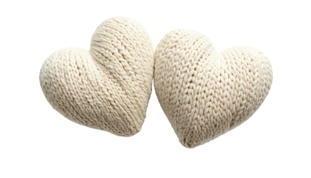 Two ivory knit hearts touch on a dark backdrop, softly textured