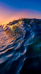 Waves making mist curl ocean at sunset reflecting golden and blue hues in the sky and water
