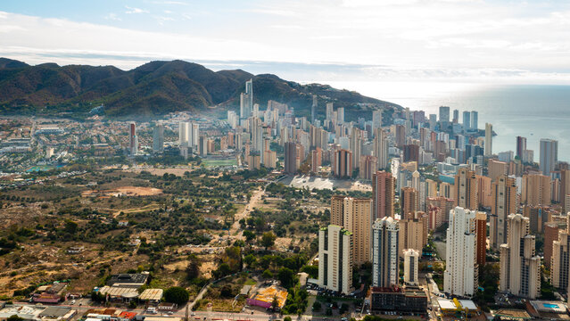 Panoram view of Benidorm showing its tall residential towers, beaches, and deep blue Mediterranean Sea. Vibrant resort city on the eastern coast of Spain.