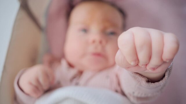 Close up of baby's tiny hand reaching out gently in soft pastel tones