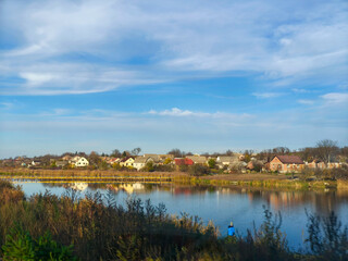 A person standing on the edge of a lake in a small town