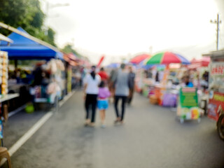 Obraz premium People walking along a street market, enjoying the sights and sounds of outdoor vendors.