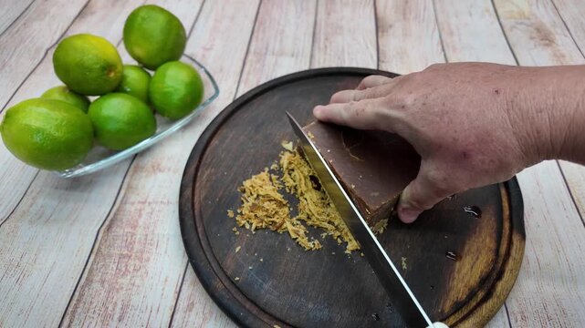 Cutting panela block for cooking on wooden board in bright kitchen setup