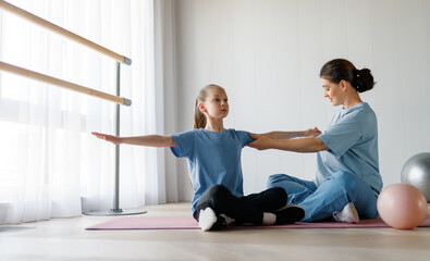 Obraz premium girl doing exercises under doctor's supervision