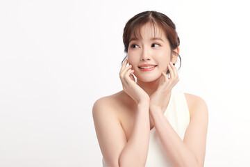 Fototapeta premium A beautiful young Asian woman with clean, fresh skin against a white background. Skincare, facial treatment, cosmetology, beauty, and spa. An elegant portrait of an Asian woman.