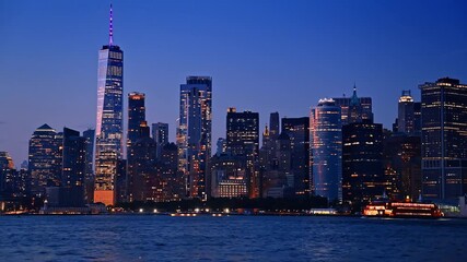 New York skyline glowing at twilight with illuminated skyscrapers. Panoramic view of the New York skyline at twilight with skyscrapers shining brightly over the Hudson River. - Powered by Adobe