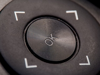 Macro image reveals textured navigation button with direction symbols and concentric circles.
