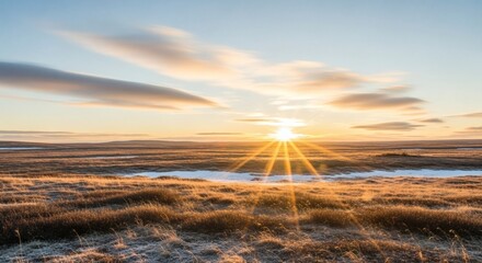 A picturesque sunrise over a vast open field, with streaky clouds and the sun's rays