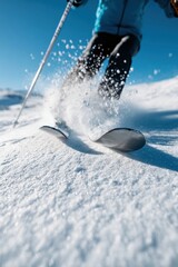 A skier glides through fresh snow, creating a spray under bright blue skies, showcasing the thrill of winter sports.