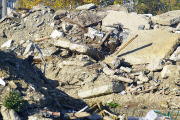 Pile of concrete rubble mixed with rebar and construction debris at demolition site. Symbolizes building deconstruction process, urban redevelopment cycle, and post-industrial landscape transformation