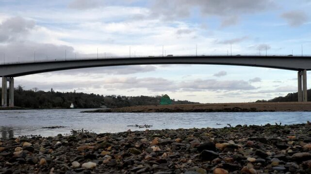 Closeup of gravel at low tide on the River Foyle near Derry Londonderry with a single span of the Foyle Bridge