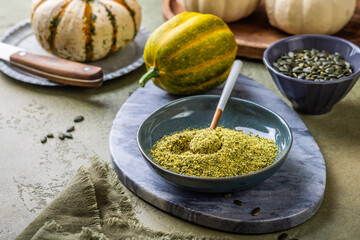 Pumpkin seed flour in a bowl with seeds, healthy food concept