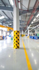 Blurred factory interior with yellow column
