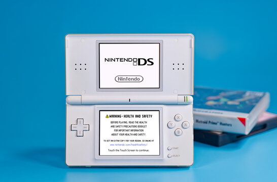 Fukuoka, Japan - november 4, 2025 : nintendo DS with game cartridges isolated on blue background