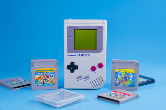 Fukuoka, Japan - november 4, 2025 : nintendo game boy with various hit game cartridges isolated on blue background
