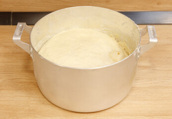 A large silver pot with a white dough in it