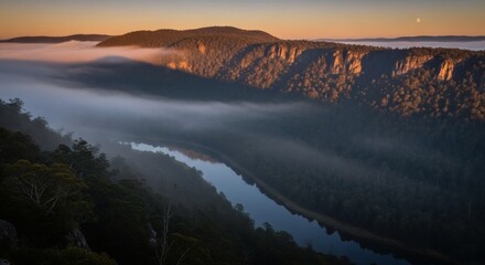 Sunrise over a valley with a river, trees, and fog. The moon is in the sky